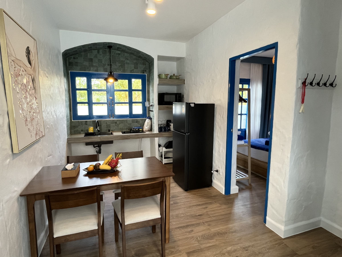 Full kitchen with dining table and a blue-framed window